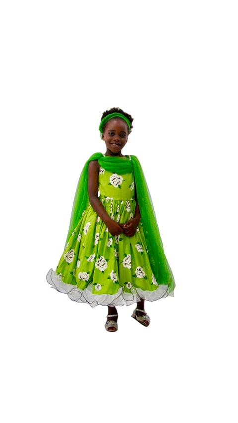 Young child wearing a bright green costume dress with floral patterns and a matching green cape and headband