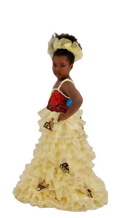 Young girl in elaborate yellow ball gown with red beaded bodice and decorative patches, wearing matching headwrap