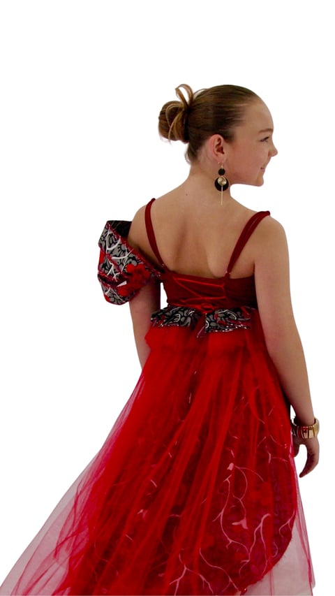 Woman in red formal gown with beaded waistband, hair in bun, wearing dangling earrings, shown from back view