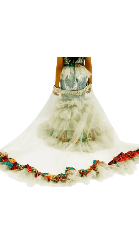 Woman wearing an ornate couture gown with pale green tulle skirt, gold embellishments